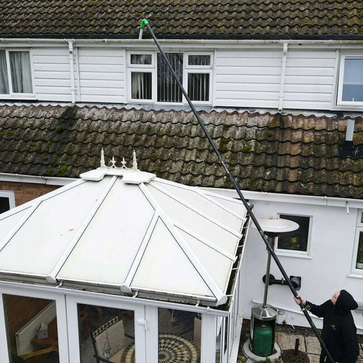 Push Fit Carbon Fibre Poles in use which is reaching over a conservatory to reach the gutters.